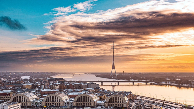 Rīgas panorāma saulrietā, kur redzams Centrāltirgus un Zaķusalas tornis.