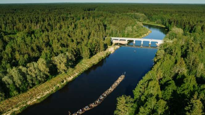 Gaujas upe ar mežainiem krastiem no putna lidojuma, tilts pār upi, upē – plosts