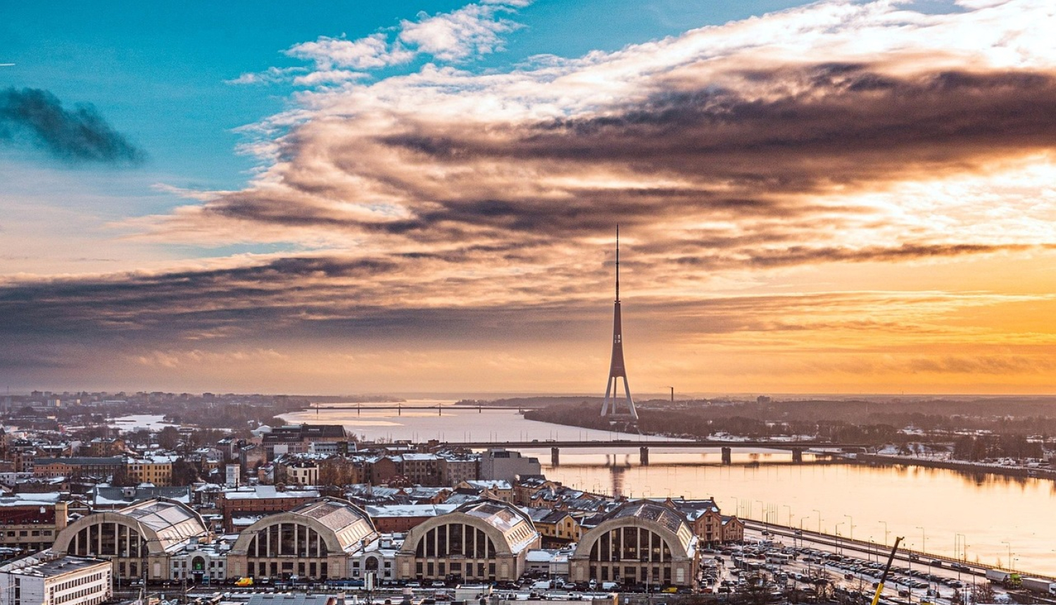 Rīgas panorāma saulrietā, kur redzams Centrāltirgus un Zaķusalas tornis.